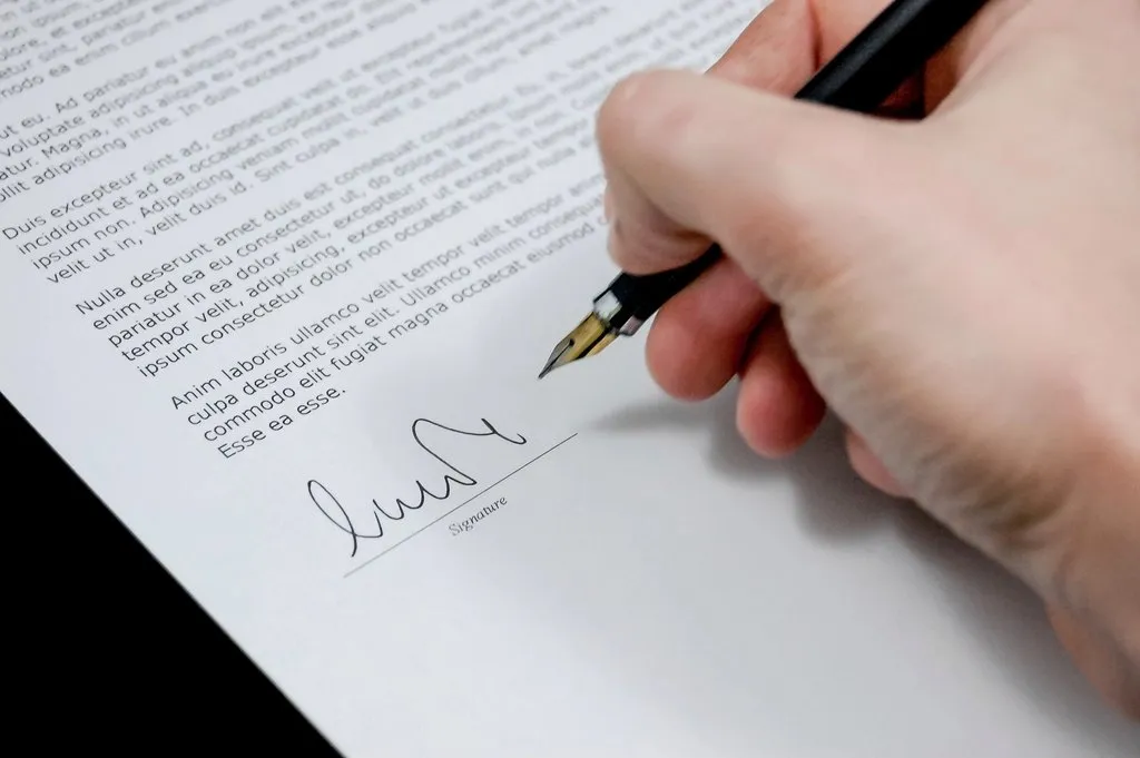 Una mano firma un documento con un bolígrafo